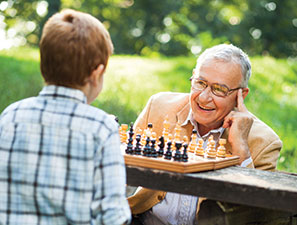 Grandfather playing chess with grandchild. Link to Closely Held Business Stock